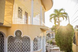 a building with a gate and a palm tree at CARNATION 156 in Montego Bay