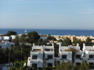 a view of a city with white houses and the ocean at Apartamentos Port D'es Torrent in San Antonio Bay