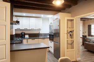 a kitchen with white cabinets and stainless steel appliances at Apartamento Bari in Plasencia
