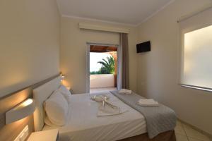 a bedroom with a bed with a view of the ocean at Flisvos Rooms in Palaiochora +117 photos