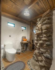 uma casa de banho com um WC e uma parede de pedra em Finca Los Abuelos - La Planta em Concepción