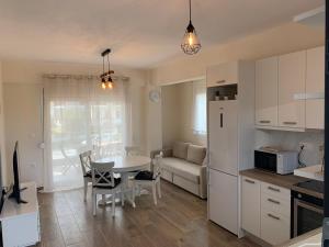 a kitchen and living room with a table and a couch at New Family Friendly Apartment in Nikiti