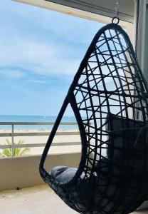 een zwarte mandstoel voor een raam met uitzicht op het strand bij "EDEN" Exceptionnel! Vue mer 10m de la plage parking privé gratuit à 100m in Canet-en-Roussillon
