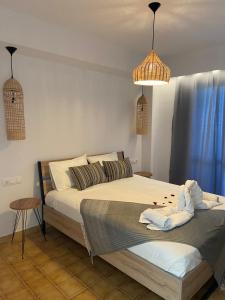 een slaapkamer met een bed en 2 hanglampen bij Manos Pension in Faliraki