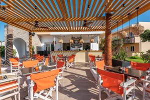 a patio at a restaurant with orange chairs and tables at Cirillo Family Hotel-Christinas Studios in Mastihari