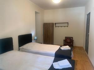 een slaapkamer met 2 bedden en een houten vloer bij Hotel Lemi in Mestia