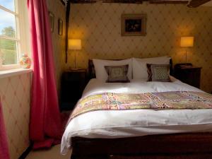 サックスマンダムにあるCrown House Great Glemhamのベッドルーム1室(赤いカーテン付きの大型ベッド1台付)