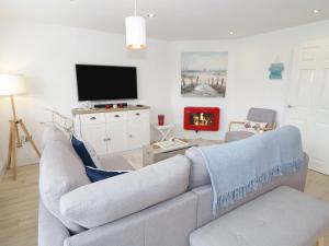 a living room with a couch and a tv at Cove House in Rhyl