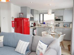 a living room with a couch and a red refrigerator at Cove House in Rhyl