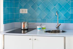 a kitchen with a sink and a blue tiled wall at B&B Sperlonga in Sperlonga +132 photos