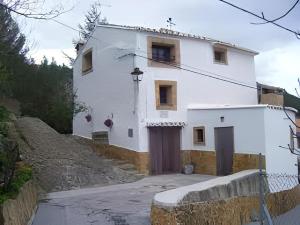 a white house on a hill next to a fence at Casa rural Teresa la Cuca in Jérica +19 photos