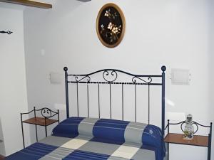 Un dormitorio con una cama azul y un reloj en la pared en Casa rural Teresa la Cuca en Jérica