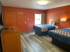 a hotel room with two beds and a flat screen tv at Economy Inn Hot Springs in Hot Springs