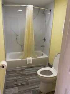 uma casa de banho com um WC, um chuveiro e uma banheira em Economy Inn Hot Springs em Hot Springs