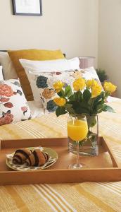 a tray with a vase of flowers and a glass of orange juice at Apartments Macaklin in Vodice