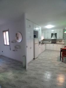 an empty kitchen with white cabinets and a table at Al lado del mercado in Vinarós +11 photos