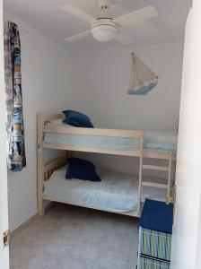Ce dortoir comprend 2 lits superposés et un ventilateur de plafond. dans l'établissement Casa Fenix, à Calp