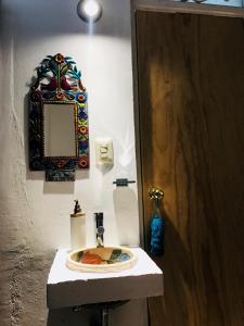 a white sink sitting under a mirror in a bathroom at Azul Cielo Hostel in Oaxaca City