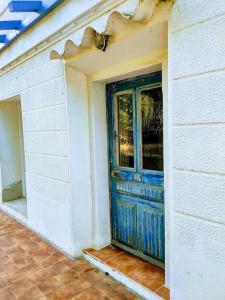 une porte bleue sur le côté d'une maison dans l'établissement Maison de charme à 200 bord de mer, terrasse, jardin- Lesclesdenicole, au Pradet