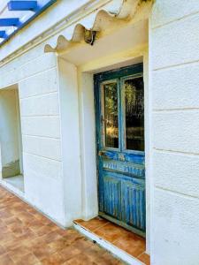 una puerta azul en el lateral de una casa en Maison de charme à 200 bord de mer, terrasse, jardin- Lesclesdenicole, en Le Pradet