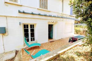 una casa con dos sillas sentadas fuera de ella en Maison de charme à 200 bord de mer, terrasse, jardin- Lesclesdenicole, en Le Pradet 11 fotos más