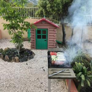 une arrière-cour avec une cabane pour chiens et un grill dans l'établissement casa Alessia, à Cala Gonone