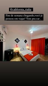 um quarto com uma cama e uma cortina vermelha em Pousada Califórnia Tia Lia em Paracuru