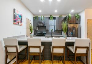 a kitchen with white chairs and a large kitchen island at Galaxy Rooftop Villa in New Orleans