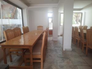 a dining room with a wooden table and chairs at Serdung Guest House in Leh