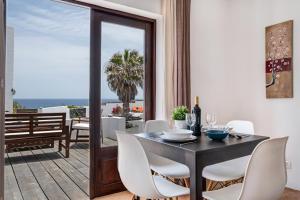 a dining room with a table and chairs and a balcony at Playa Marina Eco Bungalow Arrieta in Arrieta