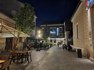 une rue vide la nuit avec des tables et des chaises dans l'établissement Fullton Central, à Cluj-Napoca