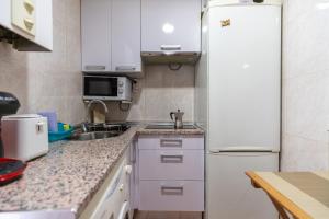 een keuken met een witte koelkast en een wastafel bij Latina I & II in Madrid