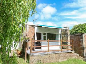 Casa pequeña con terraza y ventana en Willow Cabin, en Cowes