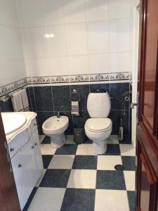 a bathroom with a toilet and a sink at De frente para o Mar in Costa Nova