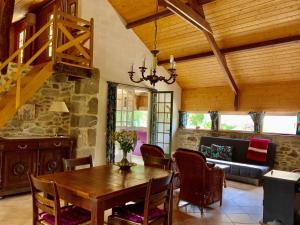 a dining room with a table and a couch at La Porcherie in Lacam-dʼOurcet