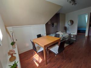 a living room with a table and chairs and a bed at Appartement calme aux portes de Rennes in Vezin-le-Coquet +1 photo