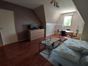 ein Wohnzimmer mit einem Sofa und einem Tisch in der Unterkunft Appartement calme aux portes de Rennes in Vezin-le-Coquet