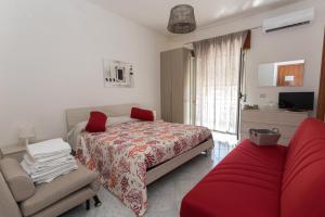 Un dormitorio con una cama y un sofá rojo. en B&B La Barcaccia en Tortora