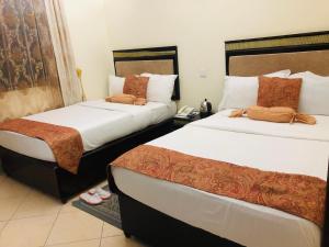 a hotel room with two beds and a phone at KAMAO Hotel in Arusha