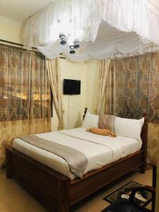 a bedroom with a large bed with a canopy at KAMAO Hotel in Arusha