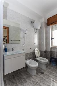 a bathroom with a toilet and a bidet and a sink at B&B La Barcaccia in Tortora