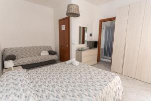 a hotel room with two beds and a bathroom at B&B La Barcaccia in Tortora