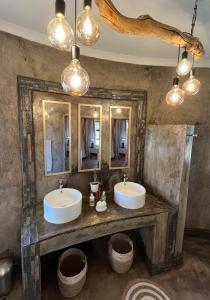 two sinks in a bathroom with two mirrors at Gamagara Africa Private Nature Reserve in Kathu