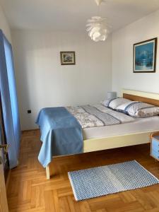 a bedroom with a bed with a blue blanket on it at Funtana Apartments Budinjaš in Funtana