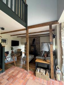 a living room with a loft with a couch and a table at Cuckoostone Barn in Buxton
