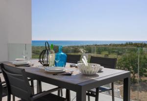 een eettafel met uitzicht op de oceaan bij Oliva Suites in Oliva