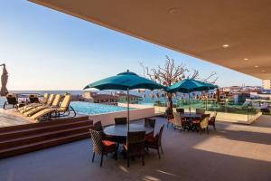 a patio with tables and chairs and a swimming pool at Nayri Life 509 in Puerto Vallarta