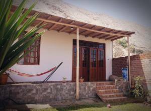ein Haus mit Holztür und Ziegelwand in der Unterkunft Lunahuaná CASA DE CAMPO PAULLU in Lunahuaná