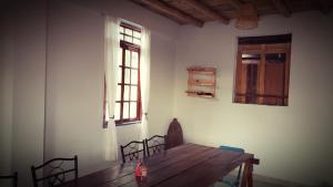 a dining room with a wooden table and a window at Lunahuaná CASA DE CAMPO PAULLU in Lunahuaná