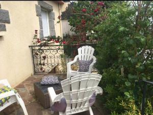 zwei weiße Stühle in einem Garten mit Blumen in der Unterkunft Appartement calme aux portes de Rennes in Vezin-le-Coquet